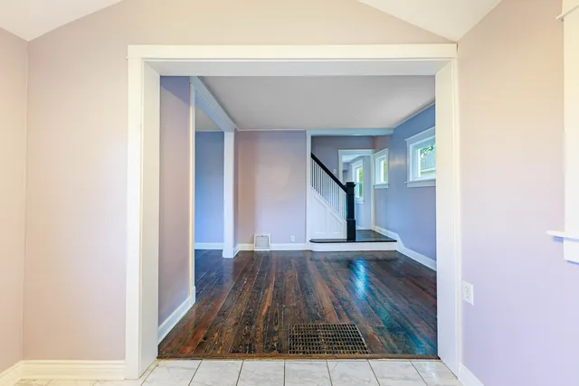 a view of a hallway with wooden floor and staircase