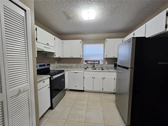 a kitchen with cabinets stainless steel appliances and a counter space