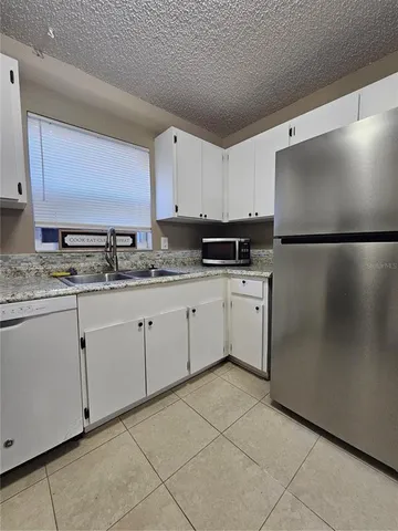 a kitchen with stainless steel appliances granite countertop a refrigerator sink and cabinets