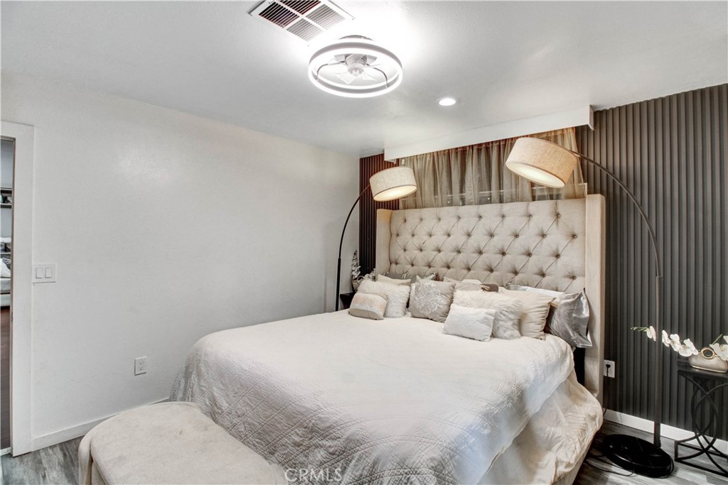 1025 South Riverside Avenue, Unit 26 Rialto, CA 92376 - Photo 16 of 27 a bedroom with a bed and a wall painting