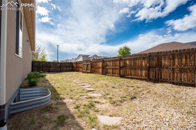 1985 Reed Grass Way Colorado Springs, CO 80915 - Photo 32 of 36 Backyard with stamped concrete, pergola, and fire pit