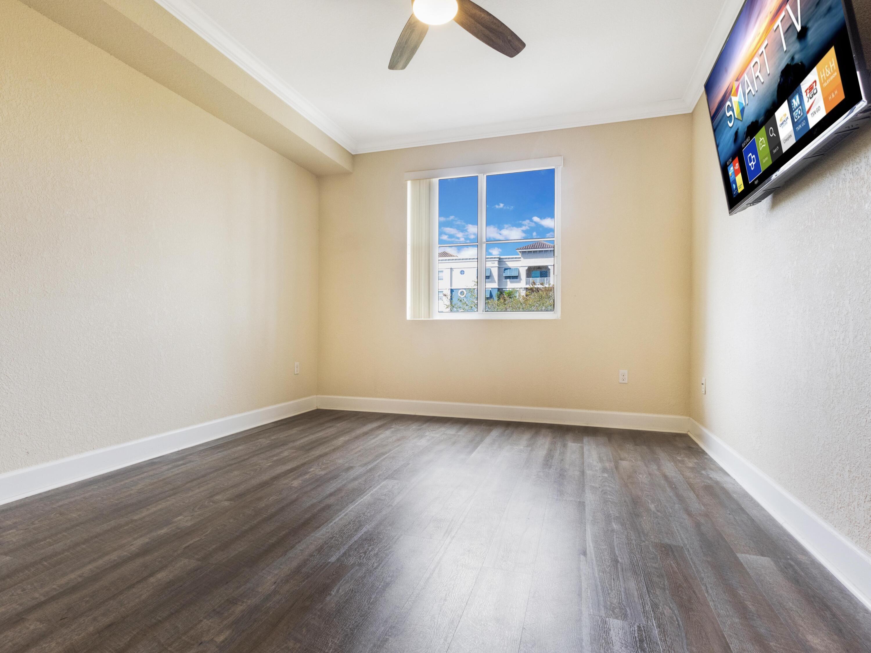 1690 Renaissance Commons Boulevard, Unit 1412 Boynton Beach, FL 33426 - Photo 20 of 49 a view of an empty room with wooden floor and a window
