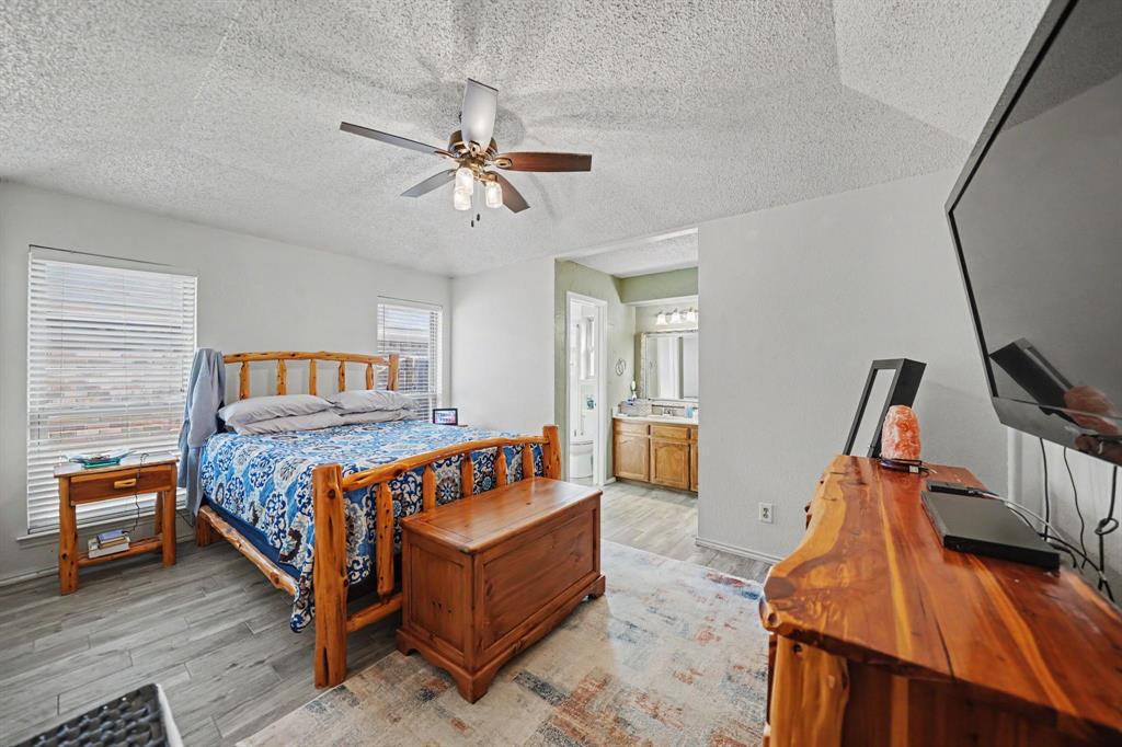 7624 Maple Hill Road Watauga, TX 76148 - Photo 12 of 20 Ceiling fan with integrated lighting, wood-finish flooring, two windows with blinds, recessed lighting in bathroom, and a vanity with dual sinks
