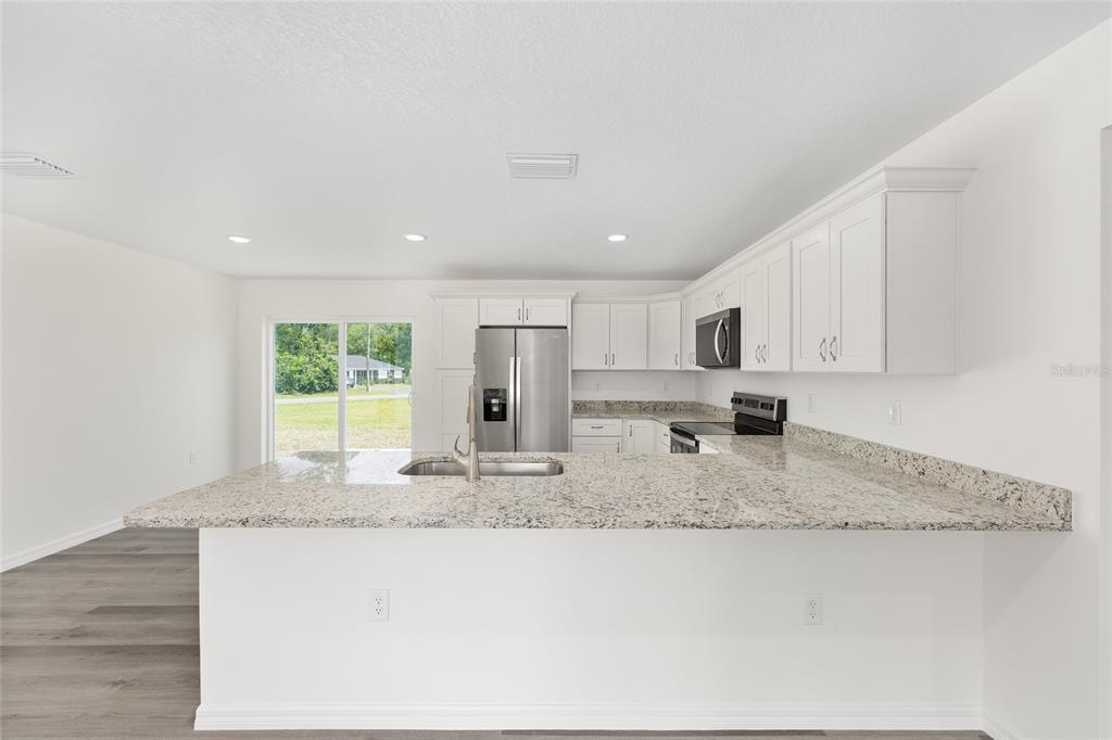 13019 Northeast 7th Loop Silver Springs, FL 34488 - Photo 19 of 35 a kitchen with stainless steel appliances granite countertop a sink and a granite counter tops