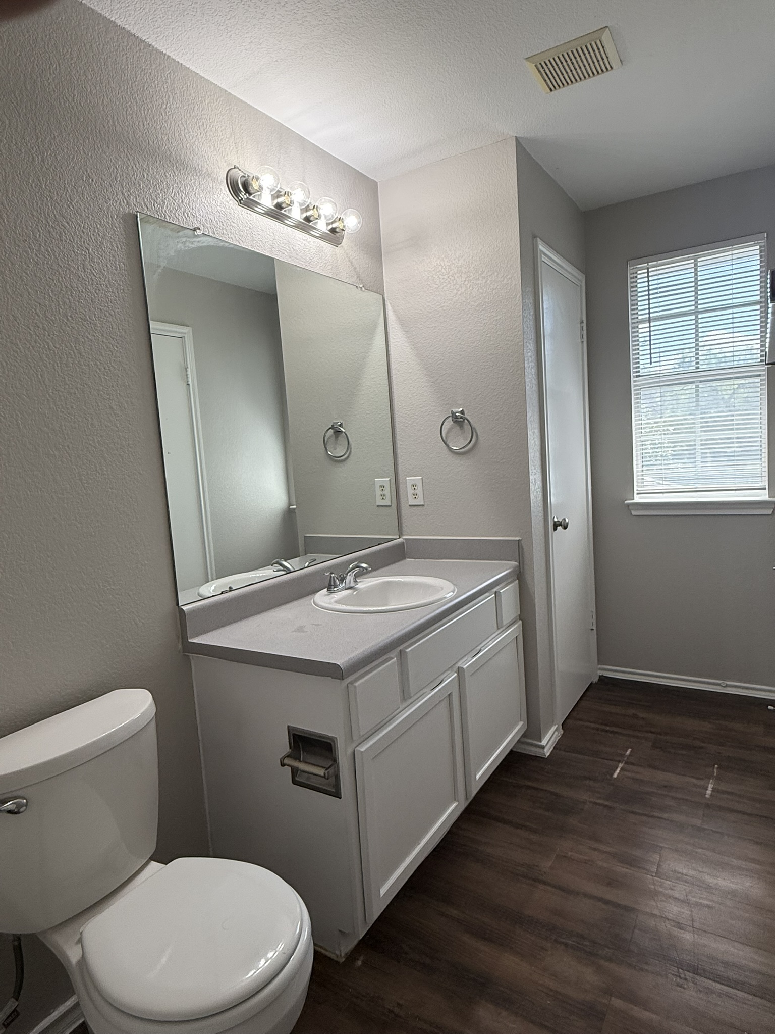 6726 Windrift Way, Unit A Austin, TX 78745 - Photo 21 of 29 a bathroom with a granite countertop toilet sink and mirror