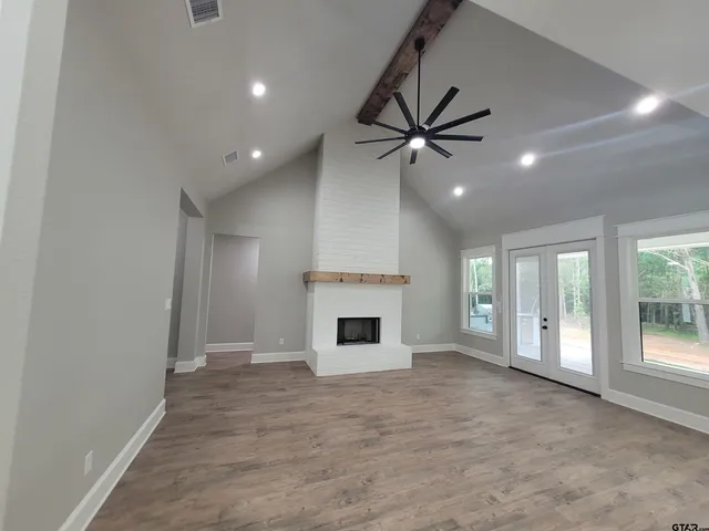 a view of room with window ceiling fan and hardwood floor