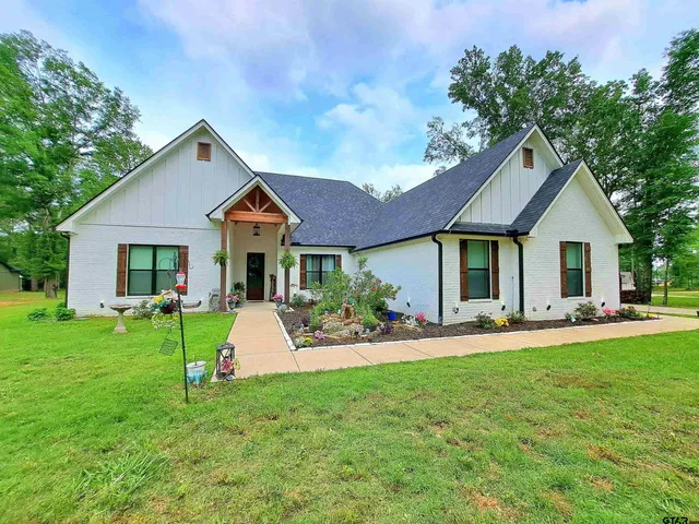 a living room with furniture kitchen view and a chandelier