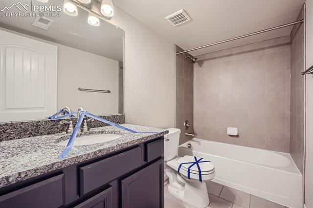 6126 Jorie Road Colorado Springs, CO 80927 - Photo 25 of 28 Full bathroom with toilet, tiled shower / bath combo, vanity, and tile patterned flooring