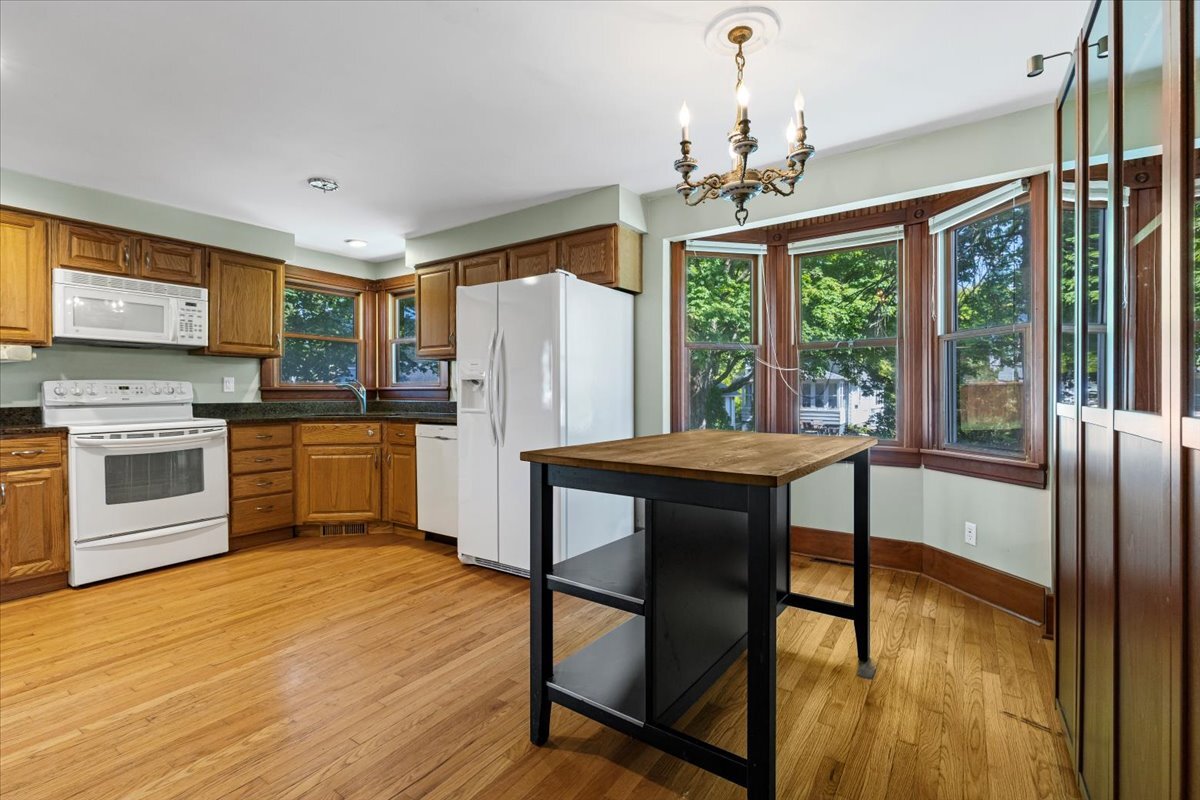 717 Edward Street Sycamore, IL 60178 - Photo 7 of 21 a kitchen with stainless steel appliances granite countertop a refrigerator a stove microwave and a dining table with wooden floor