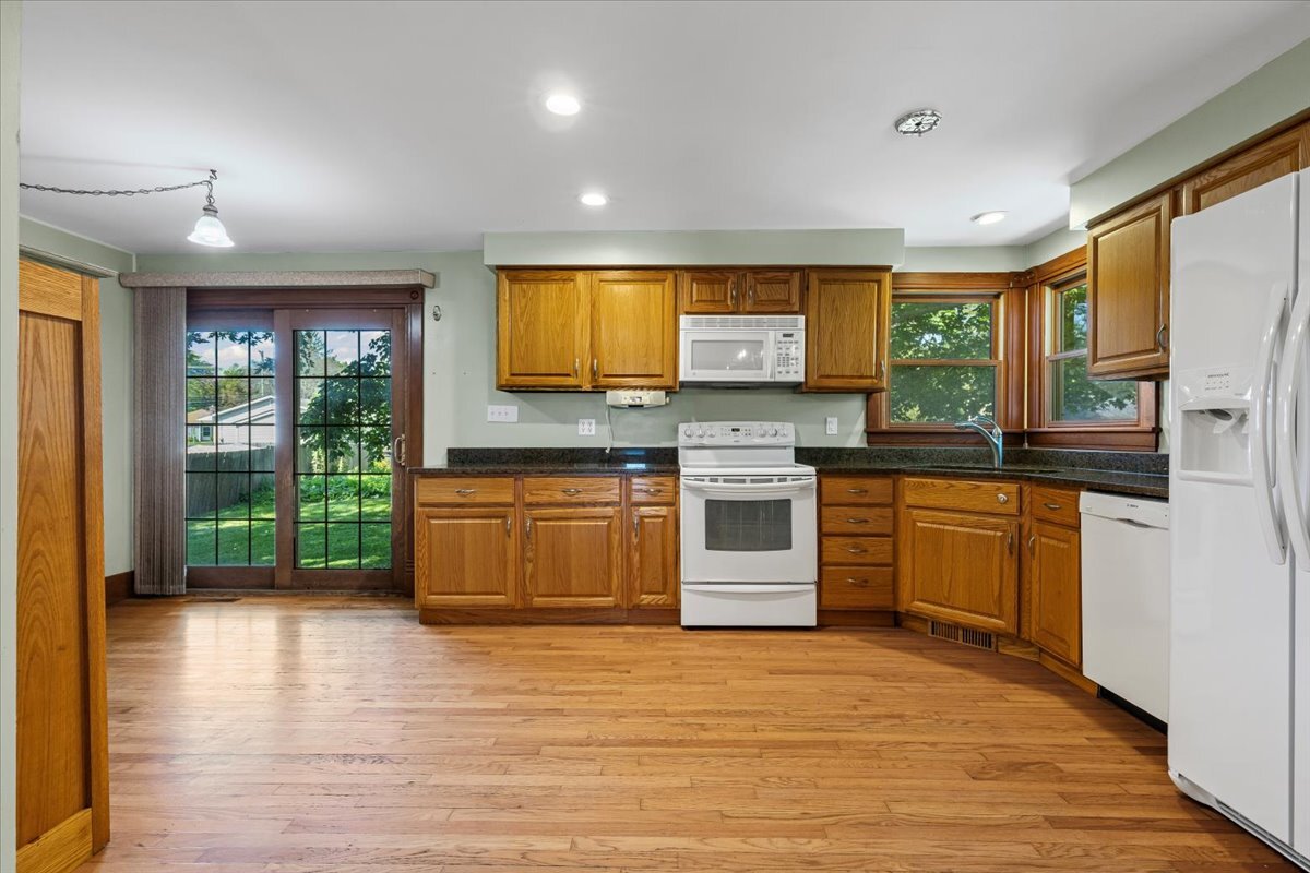 717 Edward Street Sycamore, IL 60178 - Photo 8 of 21 a kitchen with stainless steel appliances kitchen island granite countertop a stove a sink dishwasher and a flat screen tv