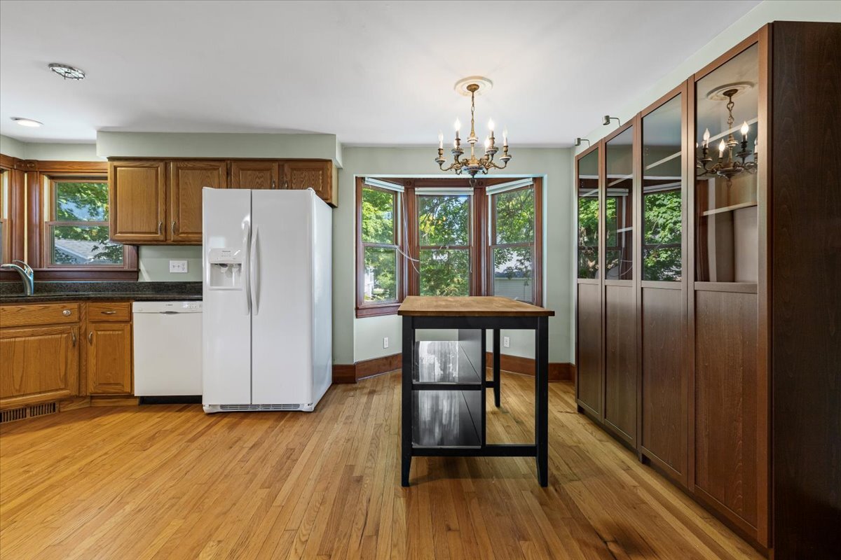 717 Edward Street Sycamore, IL 60178 - Photo 9 of 21 a kitchen with stainless steel appliances granite countertop a refrigerator a stove a sink dishwasher with a dining table and chairs with wooden floor
