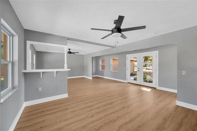 a view of an empty room with window and wooden floor