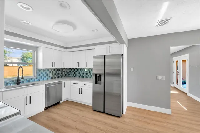 a kitchen with stainless steel appliances granite countertop a refrigerator and a sink