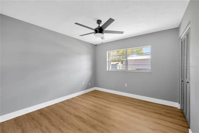 a view of a big room with wooden floor and windows