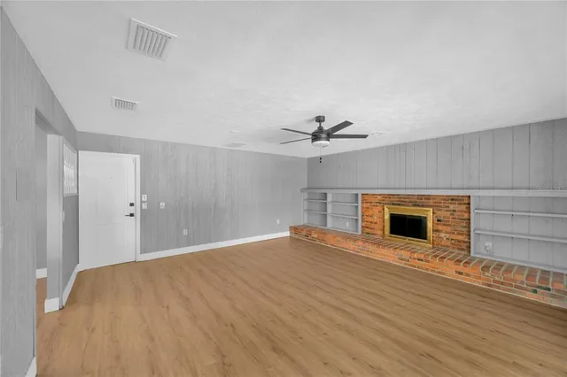 a view of an empty room with a fireplace and a window