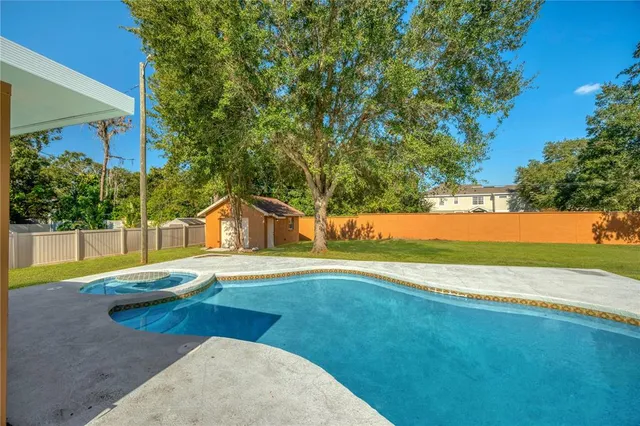 a view of a backyard with plants and a fountain