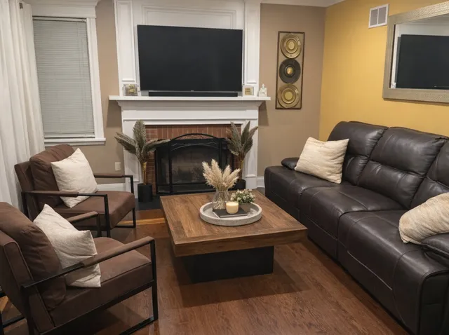 a living room with furniture a flat screen tv and a fireplace