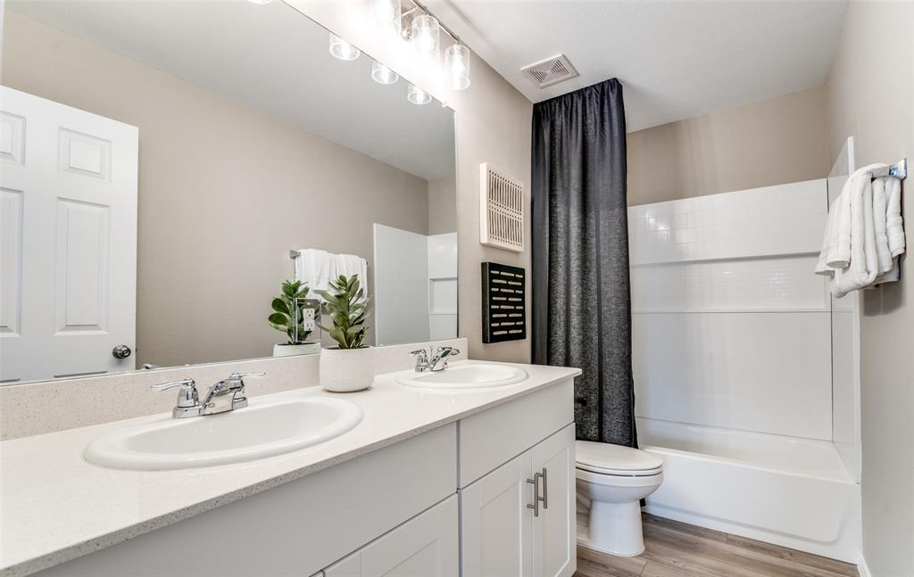 2109 Sugar Maple Lane Forney, TX 75126 - Photo 16 of 22 a bathroom with a double vanity sink toilet mirror and shower