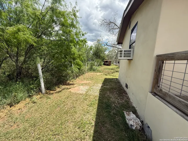 a backyard of a house with table and chairs