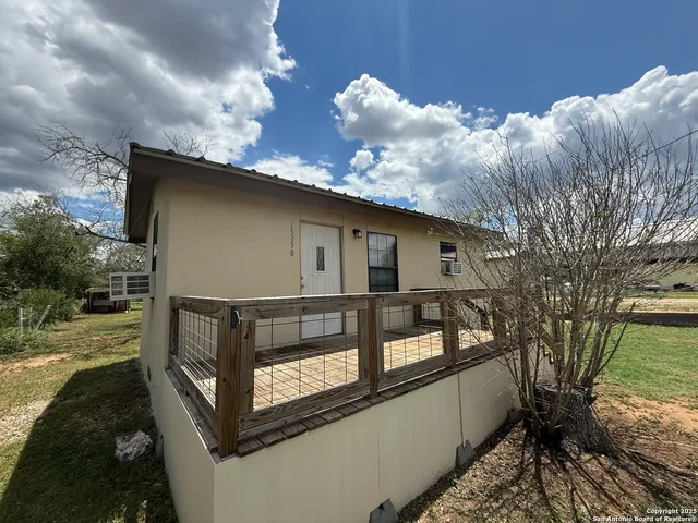 a view of a backyard with potted plants and a large tree