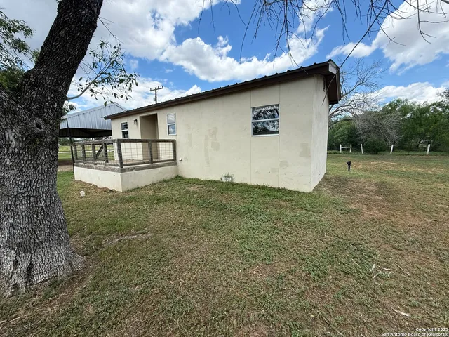 a view of a house with backyard and sitting area