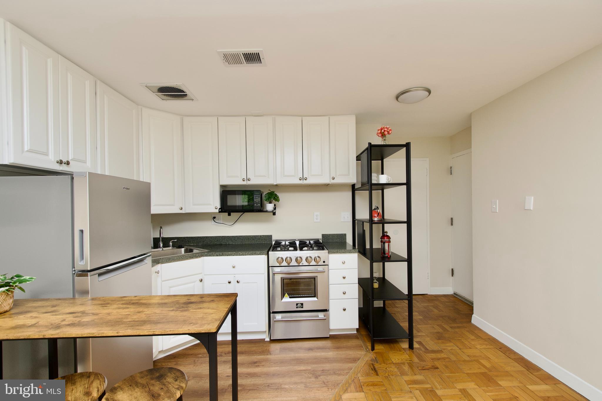 4840 MacArthur Boulevard Northwest, Unit 54 Washington, DC 20007 - Photo 15 of 28 a kitchen with stainless steel appliances a stove a refrigerator and a refrigerator