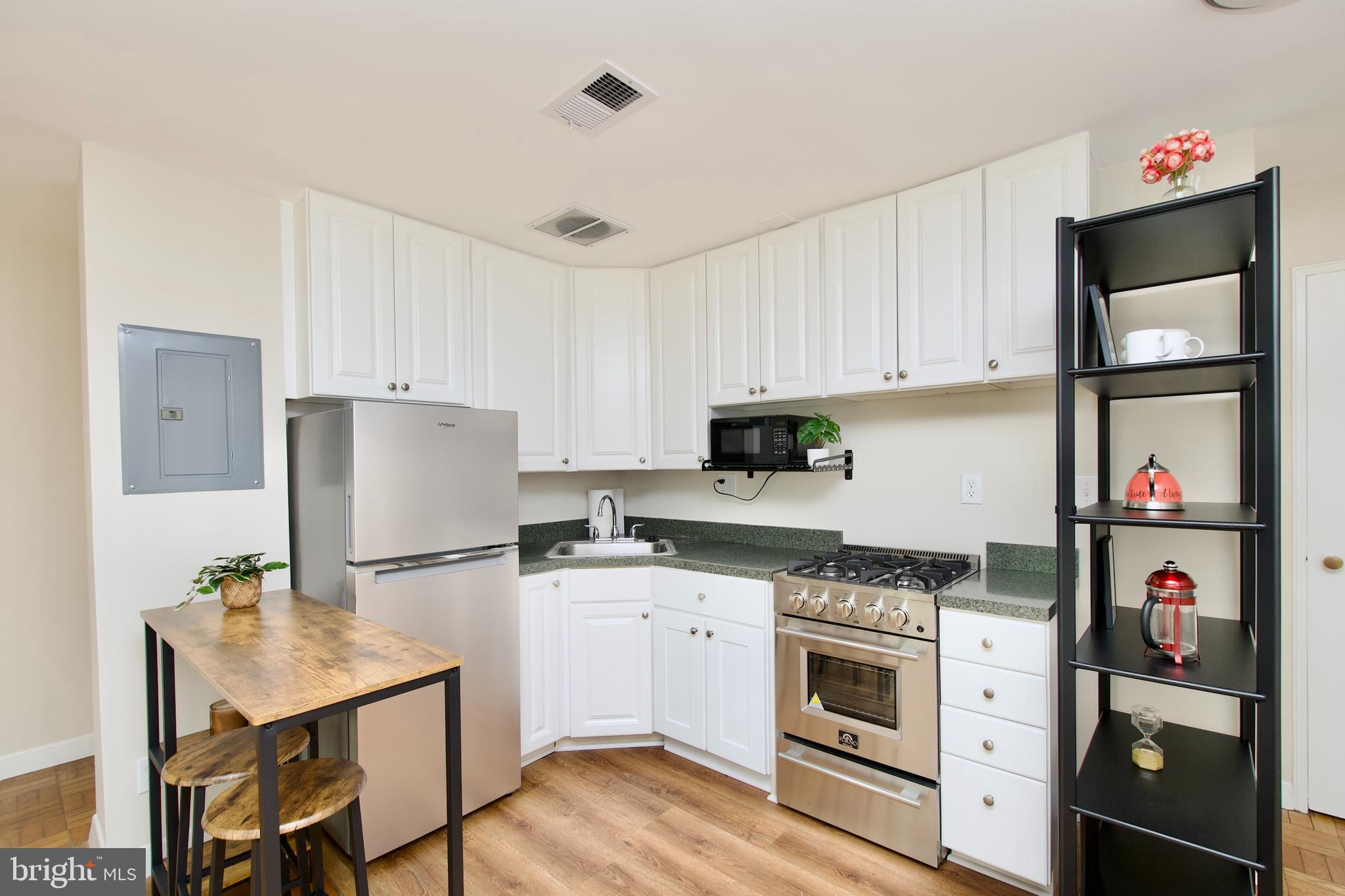 4840 MacArthur Boulevard Northwest, Unit 54 Washington, DC 20007 - Photo 16 of 28 a kitchen with stainless steel appliances a stove refrigerator sink and cabinets
