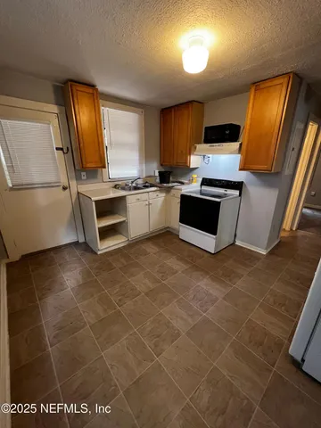 a kitchen with stainless steel appliances a stove a sink and a microwave