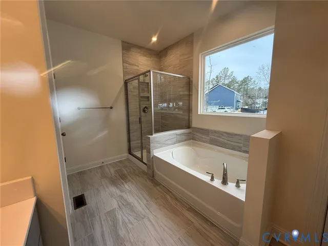 a bathroom with a tub a sink and glass door