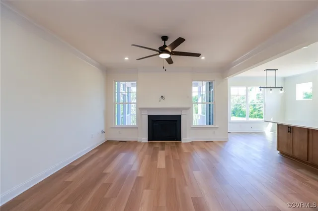 a view of empty room with wooden floor fireplace and a window
