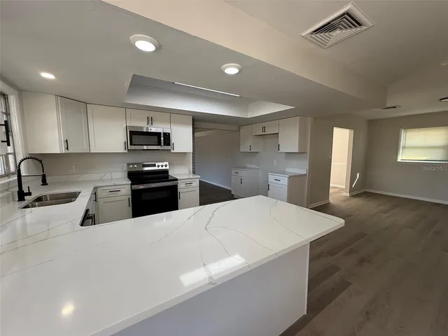 a kitchen with stainless steel appliances a refrigerator sink and microwave