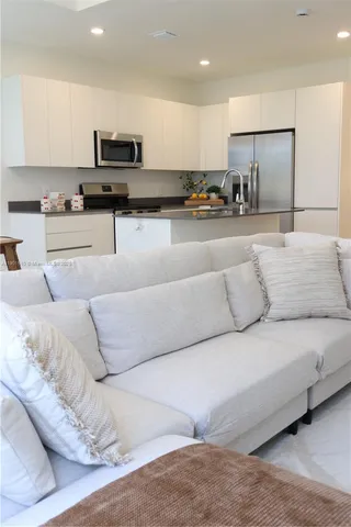 a living room with furniture and kitchen view