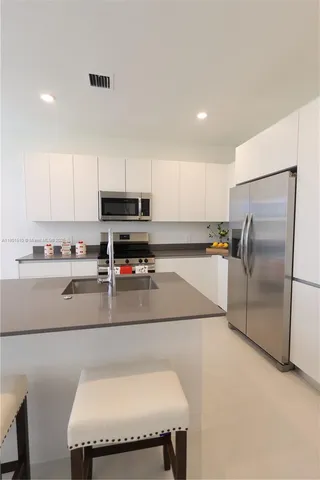 a kitchen with stainless steel appliances a refrigerator sink and microwave