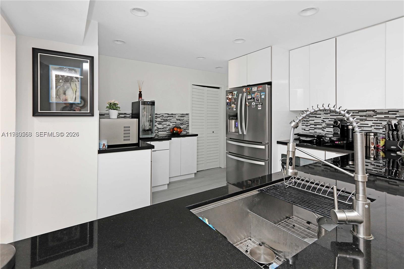 a kitchen with a refrigerator and a stove top oven