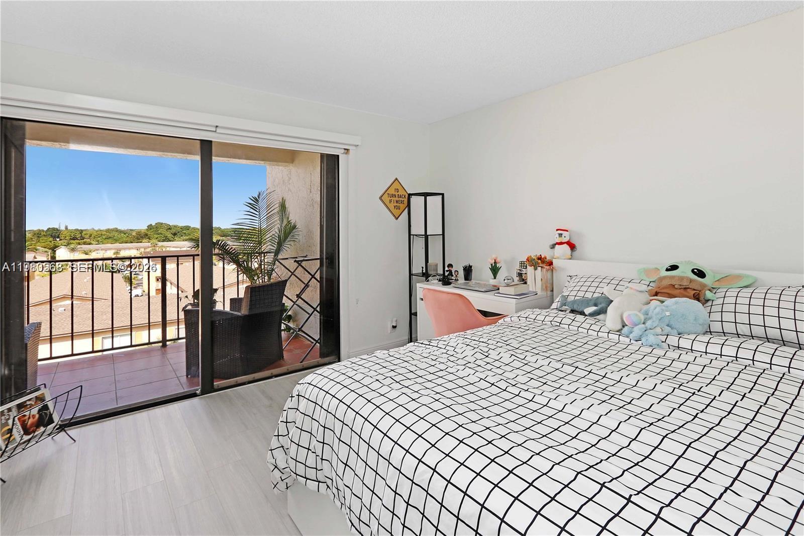 14203 Southwest 66th Street, Unit 503 Miami, FL 33183 - Photo 13 of 19 a bed room with a bed and a large window