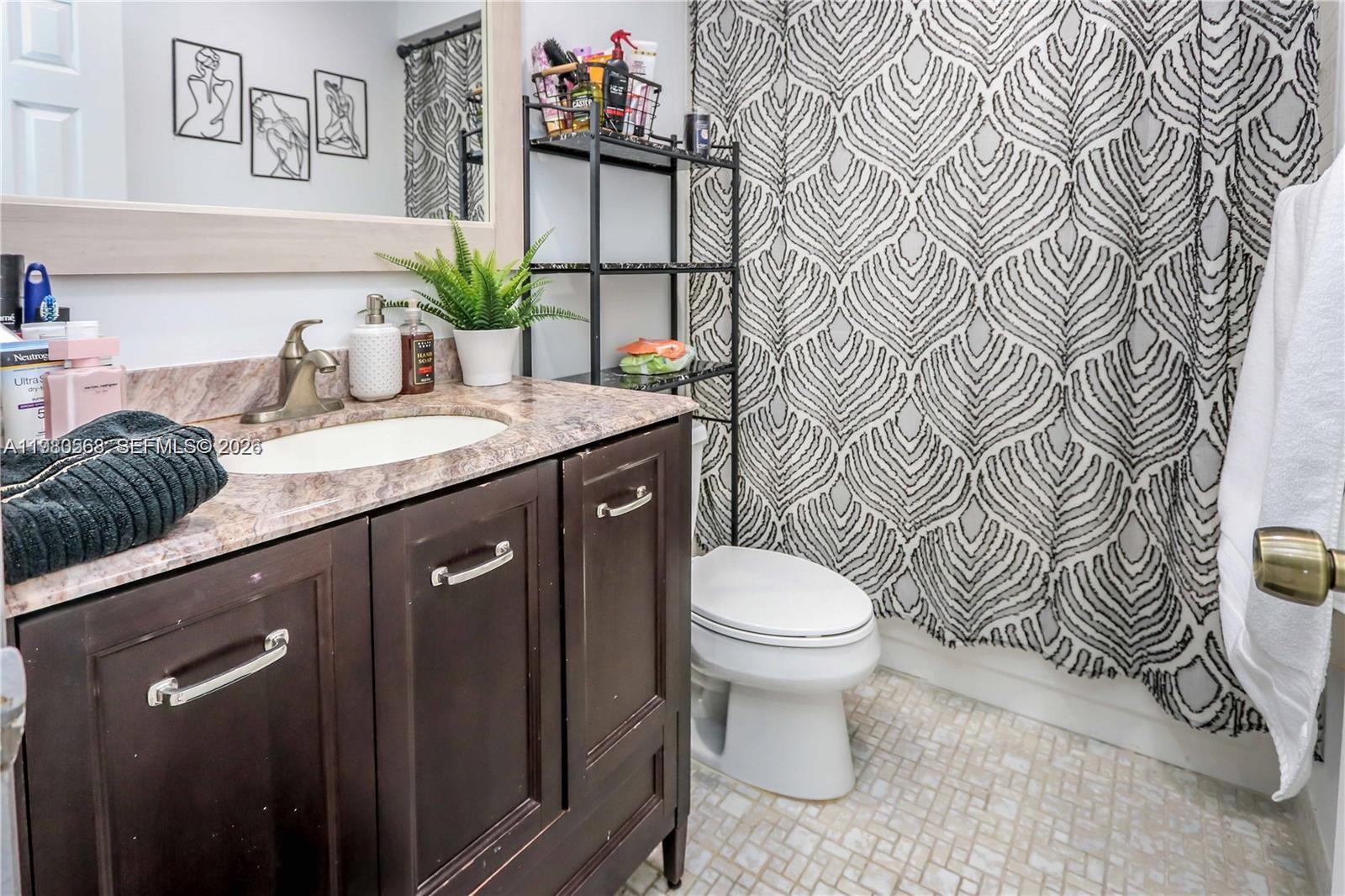 14203 Southwest 66th Street, Unit 503 Miami, FL 33183 - Photo 14 of 19 a bathroom with a granite countertop sink and a toilet