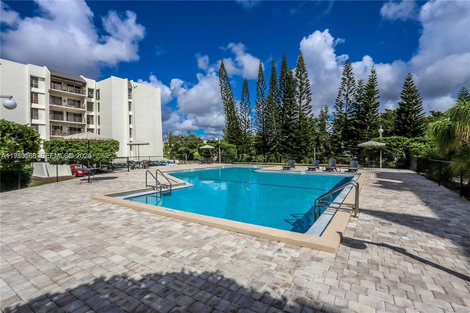 14203 Southwest 66th Street, Unit 503 Miami, FL 33183 - Photo 17 of 19 a view of a swimming pool with a patio