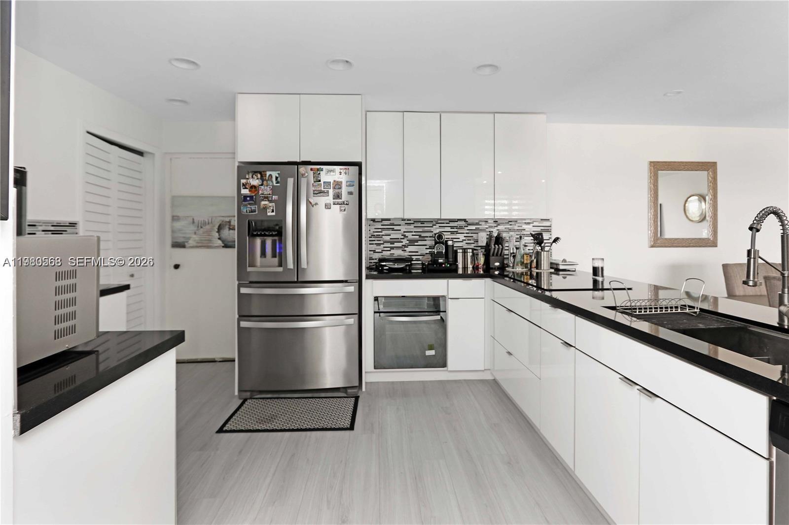 14203 Southwest 66th Street, Unit 503 Miami, FL 33183 - Photo 2 of 19 a kitchen with a refrigerator a sink and a stove top oven