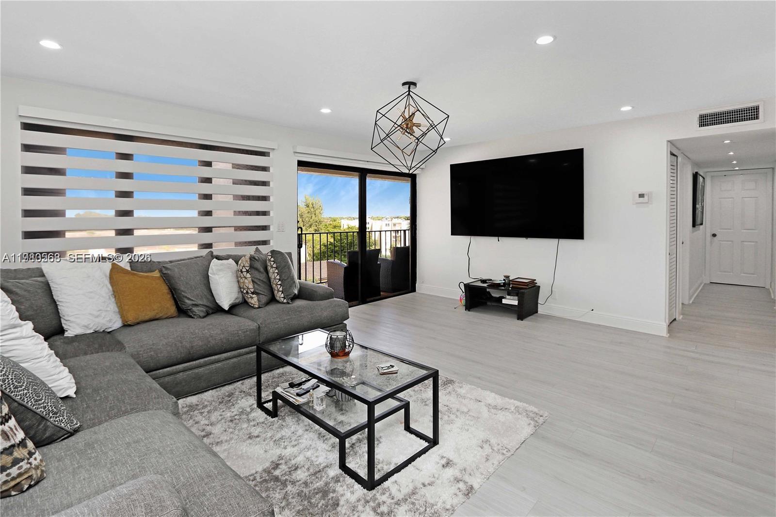 14203 Southwest 66th Street, Unit 503 Miami, FL 33183 - Photo 6 of 19 a living room with furniture a flat screen tv and a large window
