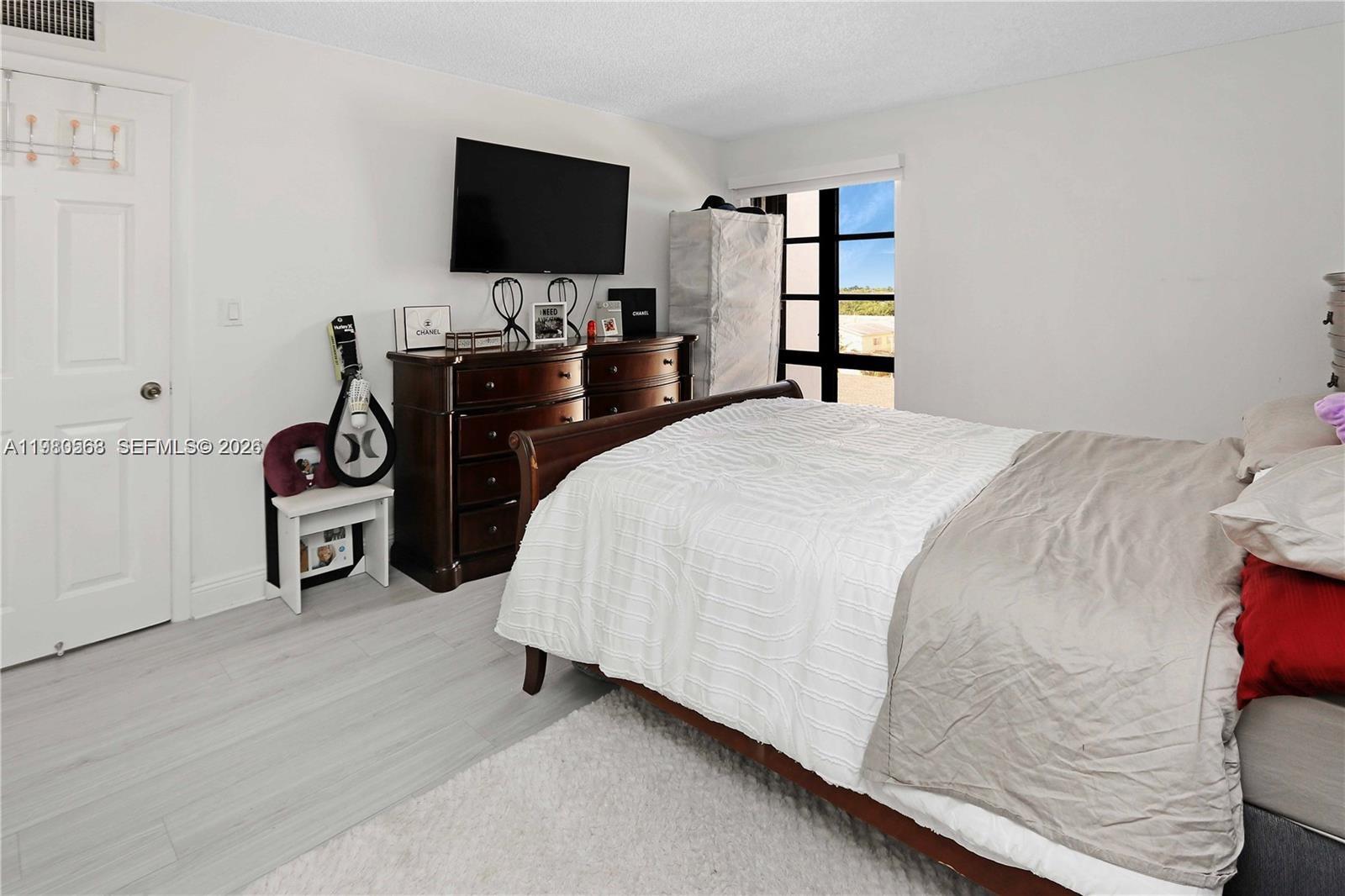 14203 Southwest 66th Street, Unit 503 Miami, FL 33183 - Photo 10 of 19 a bedroom with a bed and a flat screen tv