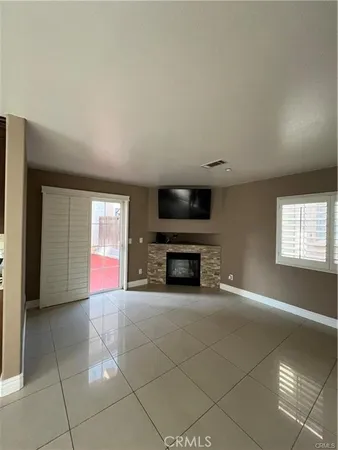 a view of an empty room with a fireplace and a window