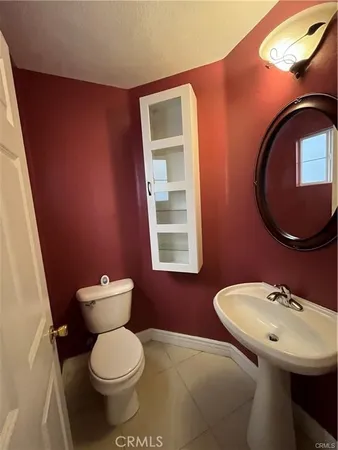 a bathroom with a toilet a sink and mirror