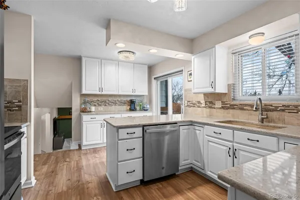 a kitchen with a sink cabinets stainless steel appliances and windows