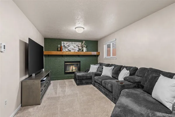 a living room with furniture a flat screen tv and a fireplace
