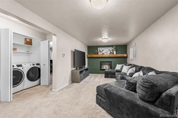 a living room with furniture a flat screen tv and a fireplace