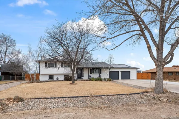 a front view of a house with a yard covered with snow