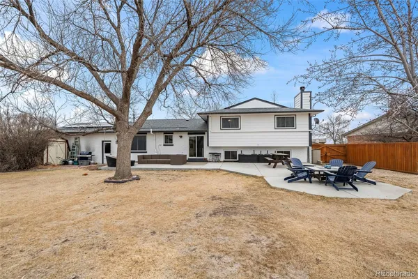 a white house that has a large tree in front of it