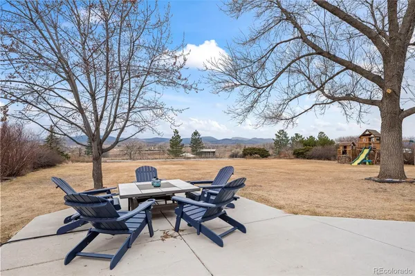 a view of a lake with table and chairs and a fire pit