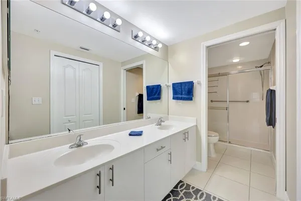 a bathroom with a double vanity sink mirror and shower