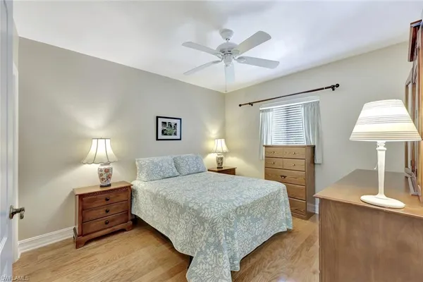 a bedroom with a bed and a lamp on dresser